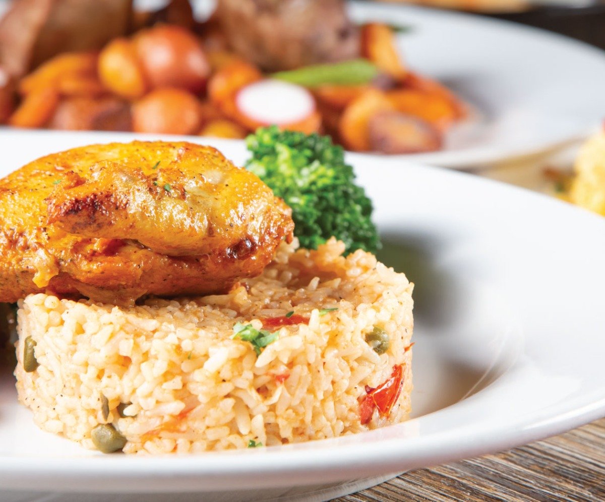 Delicious Indian food from Dhinchak white bowl with rice and chicken in, garnished with broccoli
